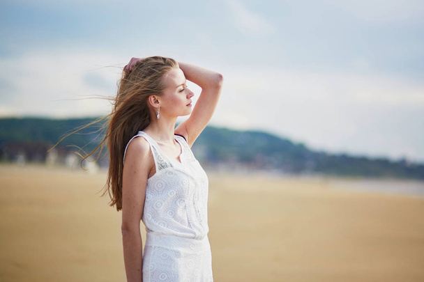 Beautiful young woman enjoying sun on a sand beach - Foto, immagini