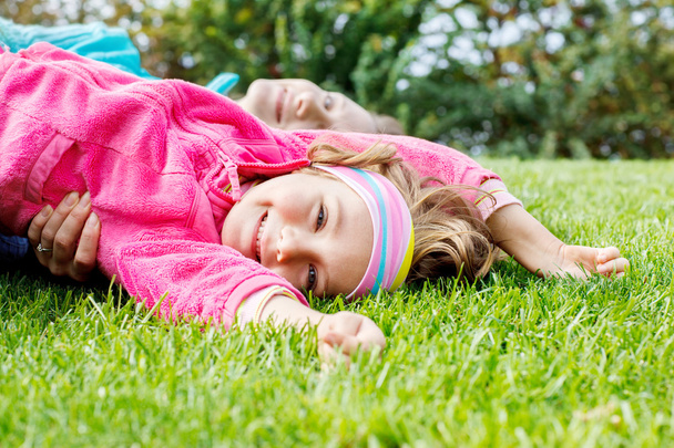 草の上に横たわるの幸せな女の子 - 写真・画像