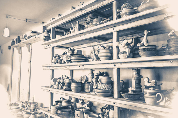 Vecchia foto d'epoca. Molte ceramiche in piedi sugli scaffali in un laboratorio di ceramica
. - Foto, immagini