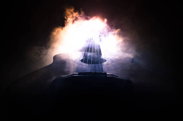 Müzik konsepti. Akustik gitar ile kopya alanı dumanla ışık demeti altında karanlık bir arka plan üzerinde izole. Gitar telleri, yakın çekim. Seçici odak. Yangın etkileri - Fotoğraf, Görsel