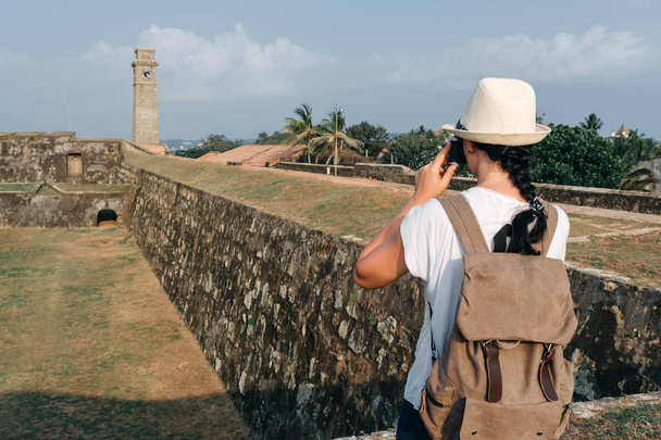 バックパックとカメラで女の子の旅行者。スリランカのゴール市街でクロック タワー - 写真・画像