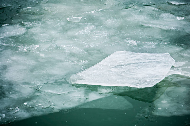 rivier- of meerwater dunne ijsbergen drijvend tijdens tij - Foto, afbeelding