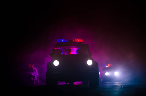 iluminación de la velocidad del coche de policía en la noche en la carretera. Los coches de policía en la carretera se mueven con niebla. Enfoque selectivo. Chase.
 - Foto, Imagen