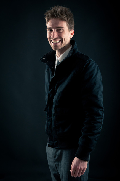 Portrait of handsome, smiling man against dark background - Fotoğraf, Görsel