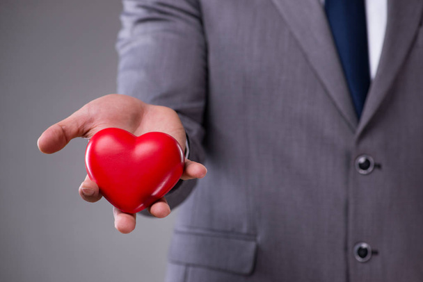 Businessman holding red heart in love concept - Foto, afbeelding