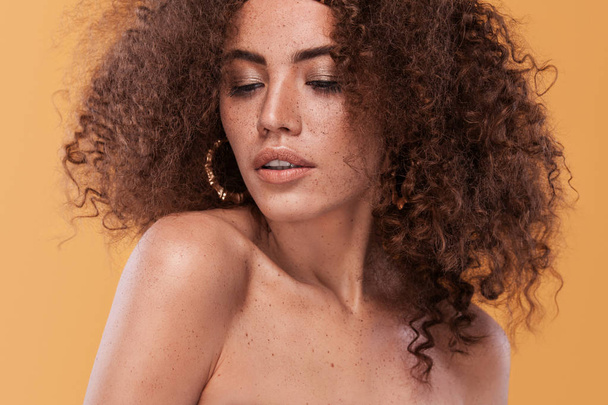 Beauty portrait of girl with afro hairstyle. Girl posing on yellow background. Studio shot. - Photo, Image