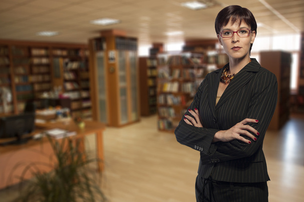 Businesswoman in a library - Фото, изображение