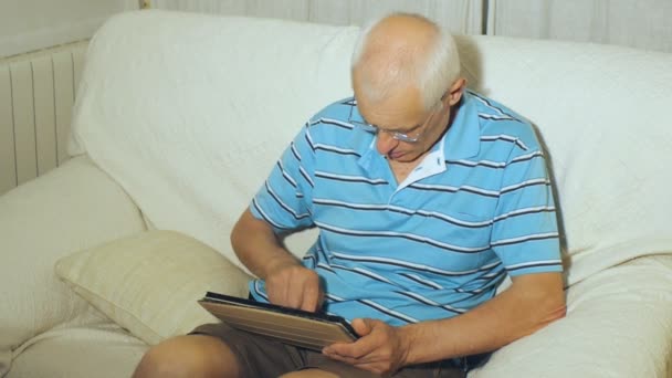 Elderly man uses tablet - Materiał filmowy, wideo