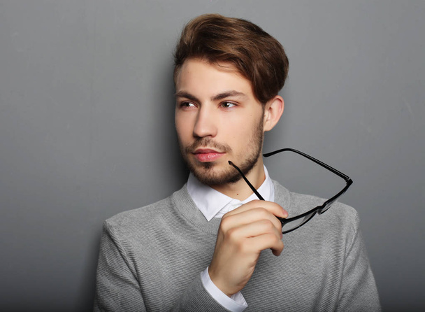 young businessman with eyeglasses, looking at the camera against - Foto, Bild