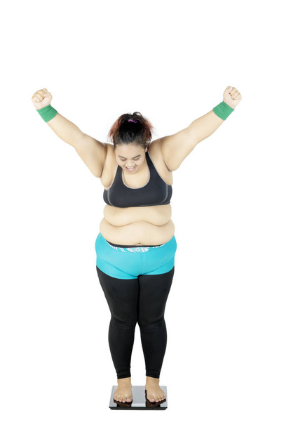 Happy fat woman stands on scale - Foto, imagen