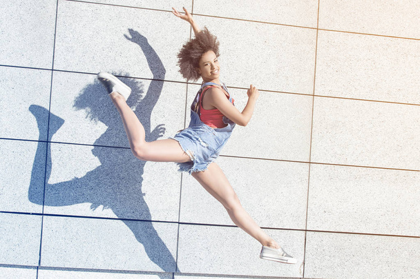 Young african american girl jumping. - Фото, изображение