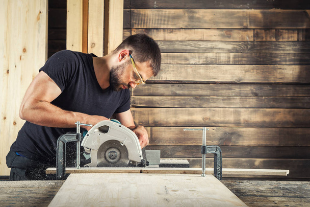 man saws a wide wooden - Photo, Image