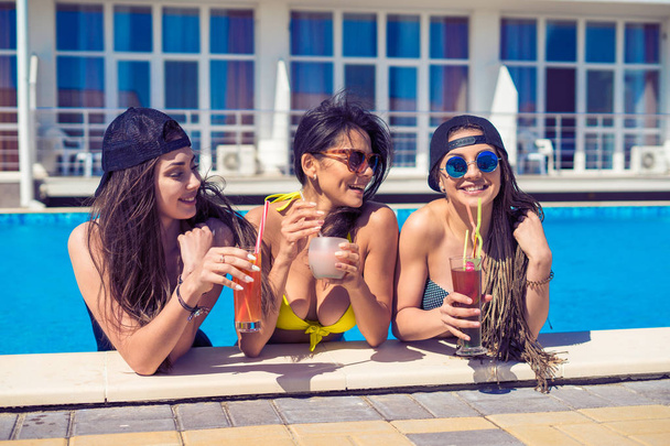 ragazze allegre bere cocktail in piscina
 - Foto, immagini