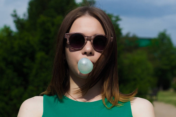 Young pretty girl chews a gum, outdoor - Fotografie, Obrázek