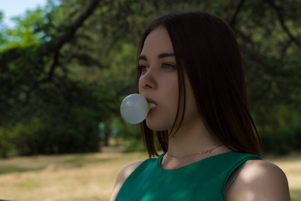 Young pretty girl chews a gum, outdoor - Фото, зображення
