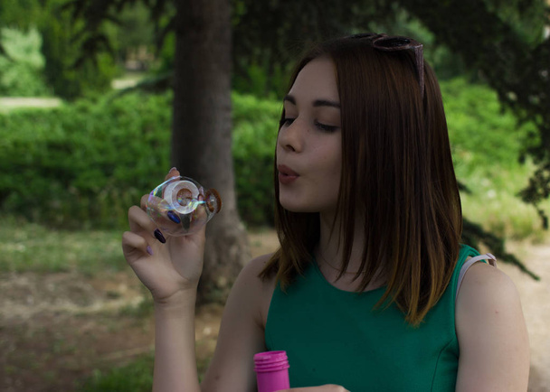Young pretty girl blows bubbles, outdoor - Foto, Imagen
