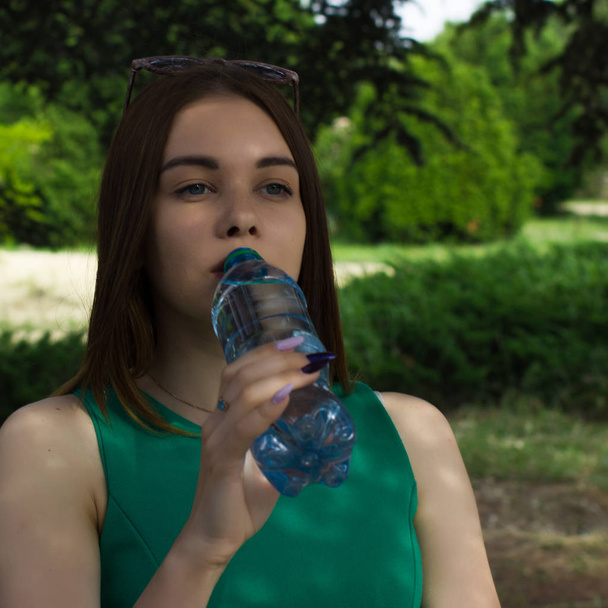 Young pretty girl drinks fresh water, outdoor - 写真・画像