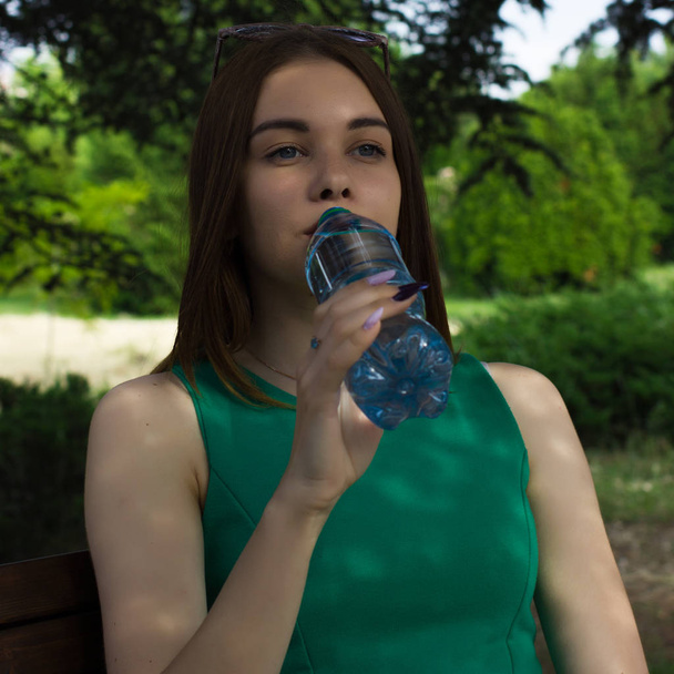 Jonge mooie meisje dranken vers water, buiten - Foto, afbeelding