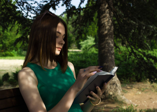 Молодая красивая девушка читает книгу, на открытом воздухе
 - Фото, изображение