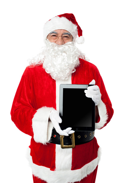 Old man in santa costume posing with a tablet pc - 写真・画像