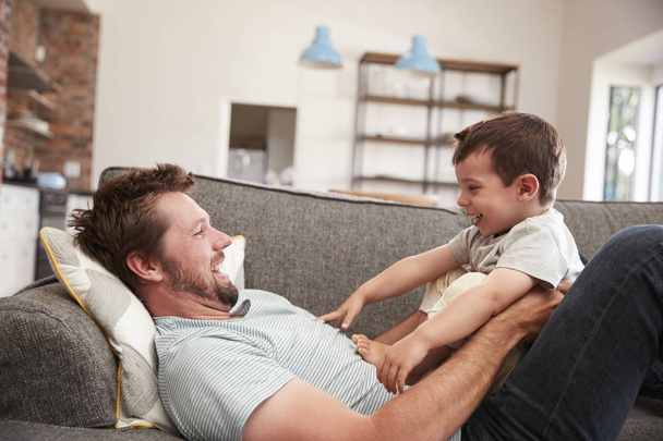 Father And Son Cuddling On Sofa  - Photo, image