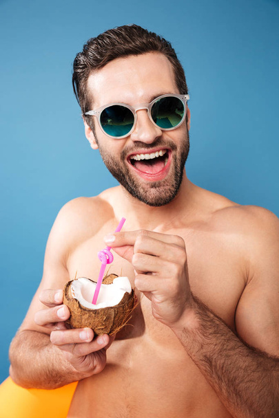 Young happy man holding cocktail from coco - 写真・画像