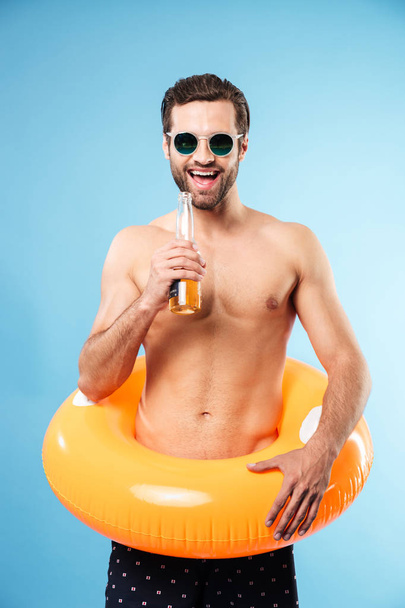 Happy smiling shirtless man wearing inflatable ring - 写真・画像