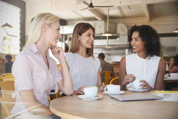 Three Businesswomen Meet In Coffee Shop  - 写真・画像