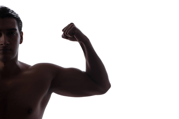 Komea mies taivuttaa lihaksiaan valkoisella
 - Valokuva, kuva