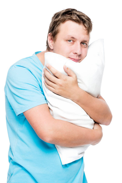 Vertical portrait of a man with a soft pillow on a white backgro - Photo, Image