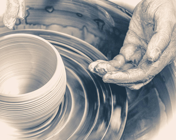 Руки мастера-гончара и ваза из глины на гончарном круге
 - Фото, изображение