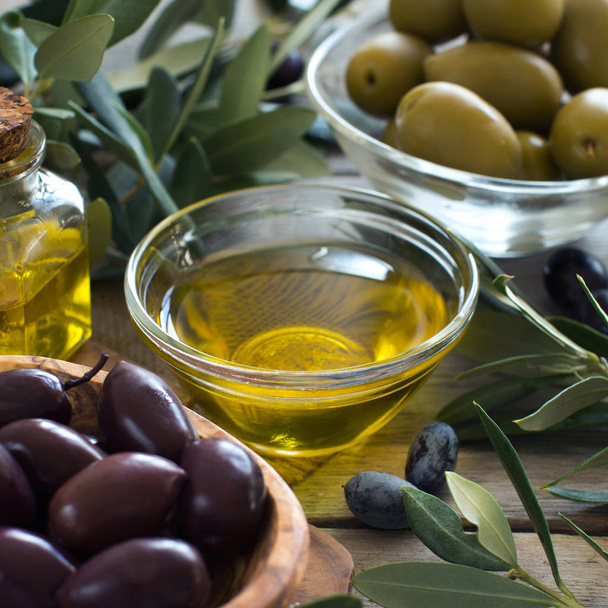 Olive oil and olives on wood background - 写真・画像