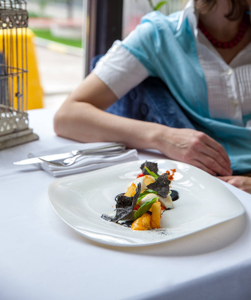 Egy étterem, egy gyönyörű hal saláta evés nő - Fotó, kép