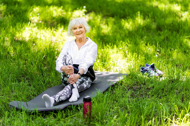 Happy senior lady having rest time after exercise outdoors - Фото, изображение