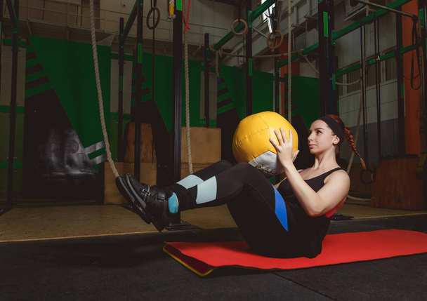 Entraînez-vous femme de remise en forme faisant des exercices assis avec boule de médecine
 - Photo, image