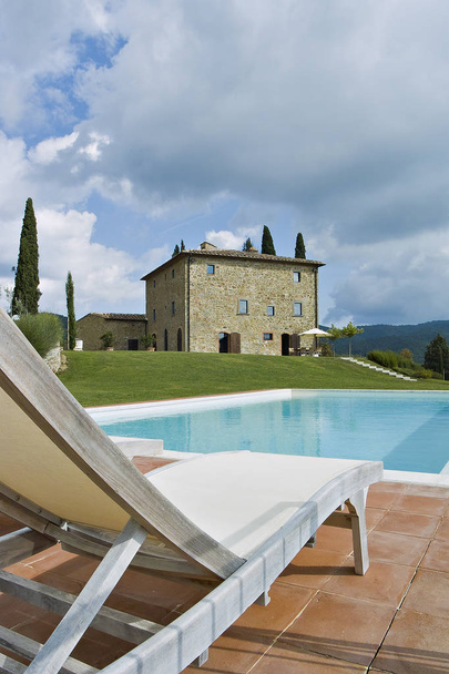 exterior furnishings near the swimming pool of a stone house - Foto, Imagen