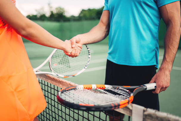 attractive couple with tennis rackets - Фото, зображення