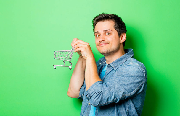Young smiling man with cart  - Foto, Bild