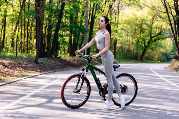 Giovane donna mista ciclista con mountain bike nella foresta allenamento ciclismo all'aperto
. - Foto, immagini