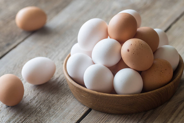 Wooden bowl of raw chicken eggs - Photo, Image