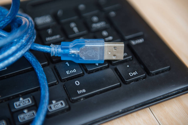 Nahaufnahme USB-Kabel auf der Tastatur. Technologiekonzept - Foto, Bild