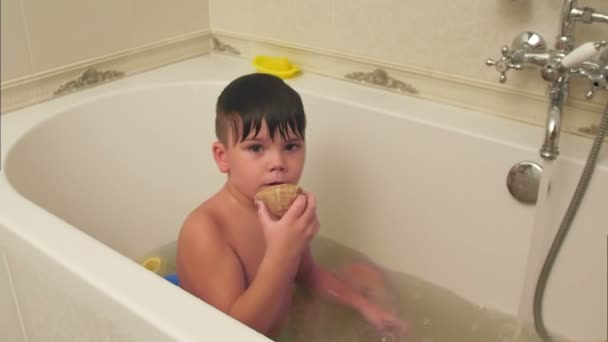 Little boy playing with seashell while taking bath in bathtub - Video, Çekim