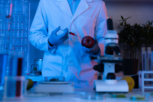 Scientist with syringe and apple  - Фото, зображення