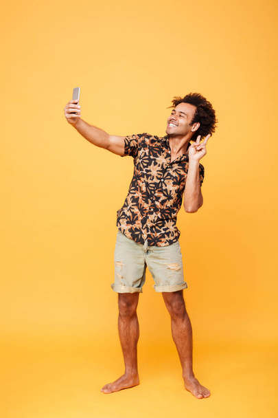 Cheerful young african man make selfie with peace gesture - Fotografie, Obrázek