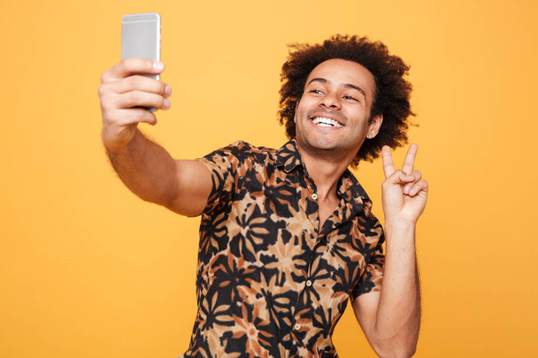 Happy young african man make selfie with peace gesture - Foto, Imagen