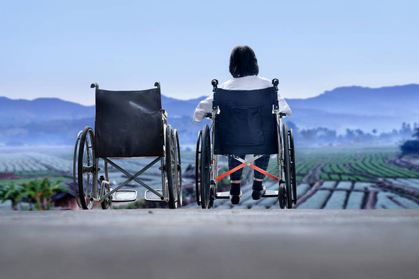 Ältere Frau mit leerem Rollstuhl steht zusammen - Foto, Bild