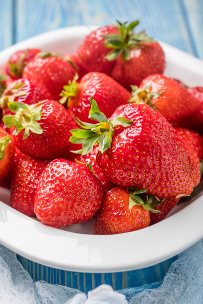 Ripe red strawberries in white bowl. - Zdjęcie, obraz