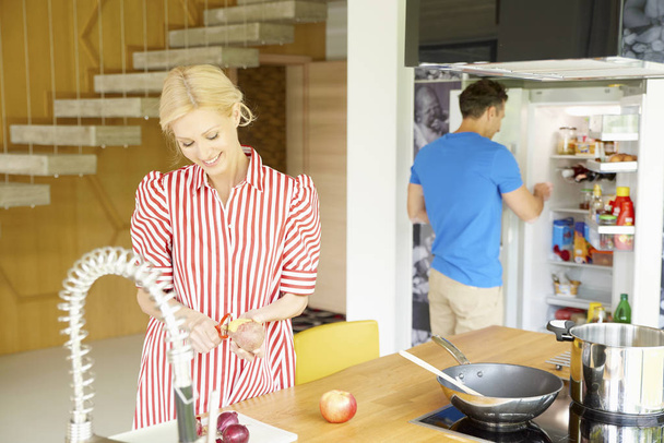 couple preparing dinner in kitchen - Foto, afbeelding