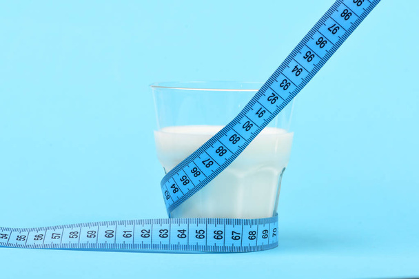 Tape for measuring wraps around glass of milk - Φωτογραφία, εικόνα