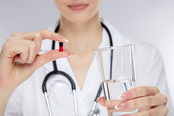 Médecin tenant pilule et verre d'eau
  - Photo, image